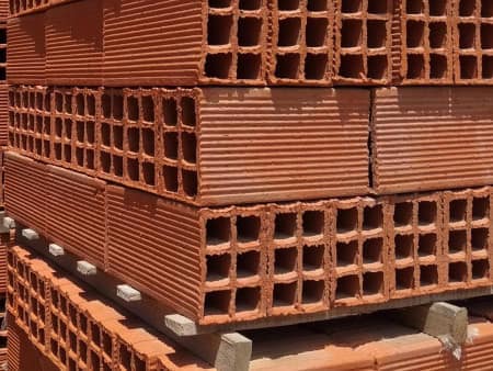 Pallets de ladrillo hueco apilados en el corralón